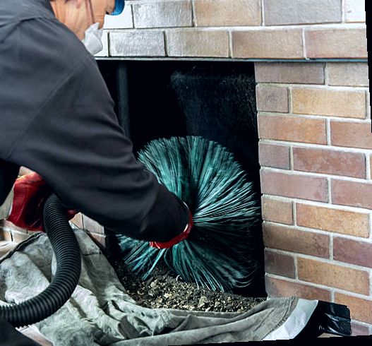 Firebox being cleaned with brush and vacuum under containment